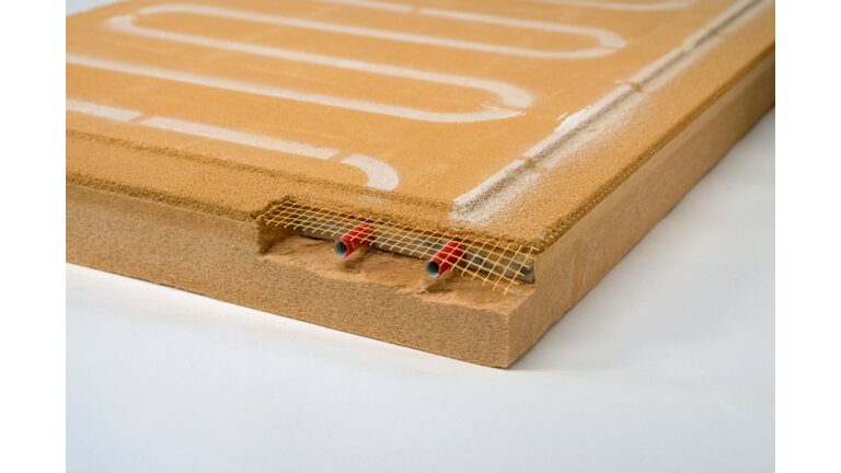 Gelbe Dämmplatte mit integrierten Heizschlangen und sichtbarem Anschlussnetz am Rand.